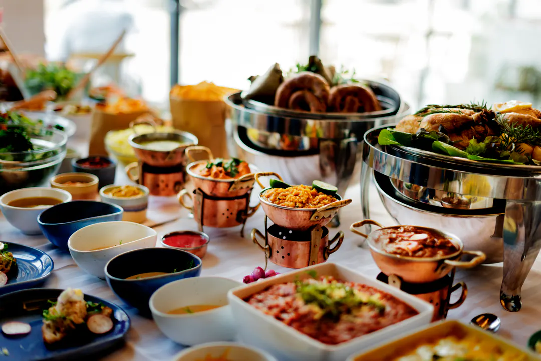 Buffet of dishes in copper serving pots and chafing trays at a catered event